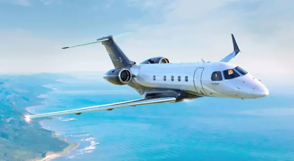 Ein modernes Privatflugzeug fliegt über dem Meer. Die Frage, wie viel kostet ein Passagierflugzeug, ist komplex, aber dieses Modell ist ein Luxusgut.