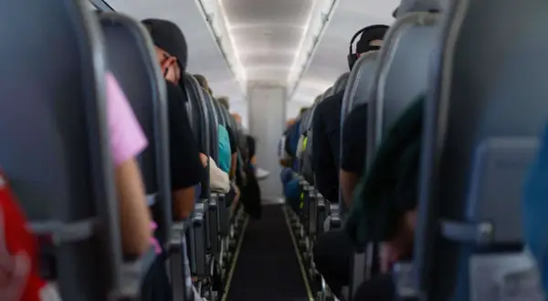 Blick in die Kabine eines Flugzeugs mit Passagieren auf ihren Sitzen. Die Wahrscheinlichkeit eines Flugzeugabsturzes ist extrem gering, aber die Enge hier lässt einen über alles nachdenken.