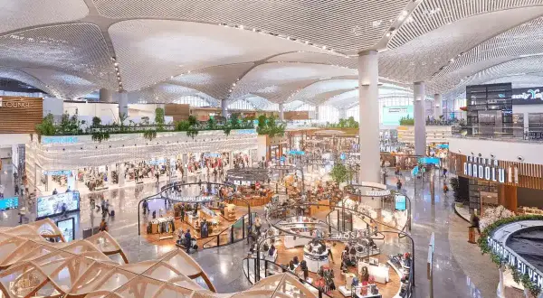Helle, moderne Einkaufsbereiche im Istanbul Flughafen mit vielen Geschäften und Menschen.