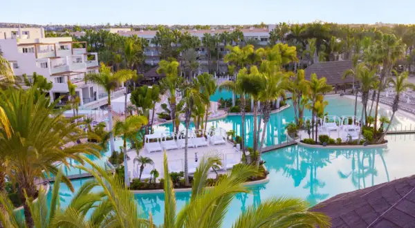 Traumhafter Poolbereich im TUI Kids Club Maspalomas Princess mit Palmen und Liegen.