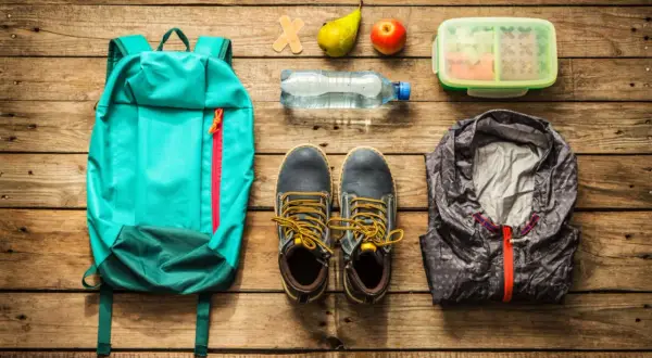 Rucksack, Schuhe, Jacke, Wasserflasche, Obst, Lunchbox und Pflaster – alles für die Packliste Klassenfahrt Lehrer.
