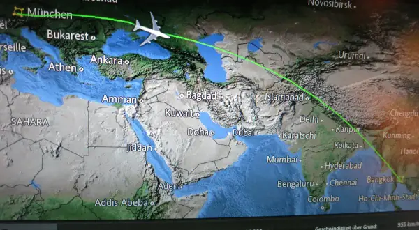 Flugroute von München nach Bangkok. Die Frage "wie lange fliegt man nach Thailand" wird durch die angezeigte Flugbahn über Asien beantwortet.