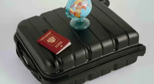 Reisekoffer mit Reisepass und Globus. Wo kann man Geld wechseln? Am Flughafen oder in der Bank.