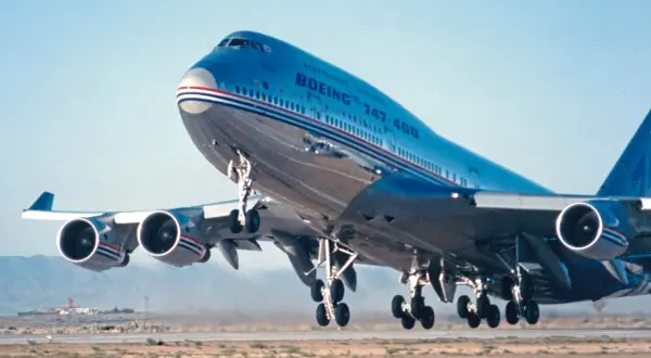 Ein Jumbo Jet 747 hebt ab, seine vier Triebwerke dröhnen.