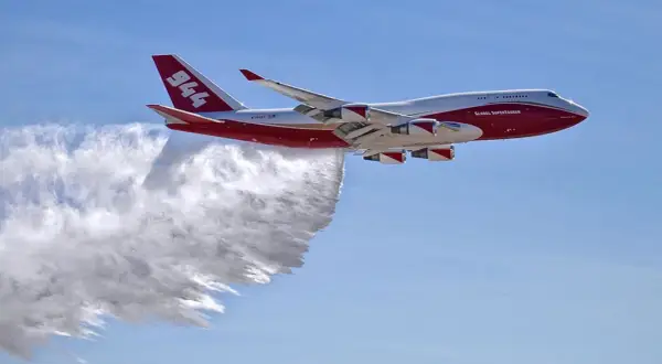 Eine Boeing 747, die als Global Supertanker zur Brandbekämpfung eingesetzt wird, sprüht Wasser. Sie fliegt schnell, um Brände zu löschen.