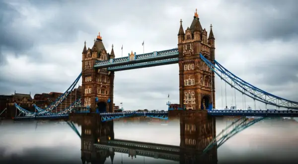 Der Tower Bridge in London, ein Wahrzeichen für jeden England Urlaub, spiegelt sich im Wasser.