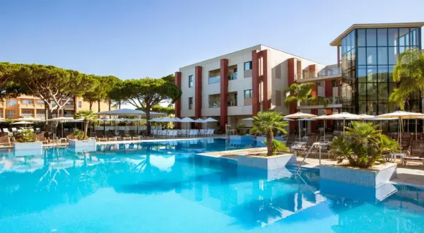 Einladender Poolbereich mit Palmen und Liegestühlen. Das Hotel mit moderner Architektur und dem TUI Kids Club Barrosa Garden verspricht einen tollen Urlaub.