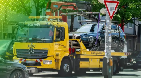 Gelber ADAC Abschleppwagen mit dunklem SUV auf der Ladefläche in Berlin. Informiert über die Kosten für Abschleppen in Berlin.