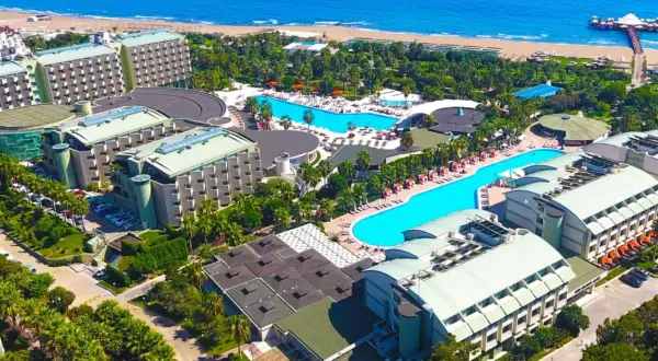 Luftaufnahme des von Resort Golden Coast, mit mehreren Gebäuden, Pools und dem Meer im Hintergrund.