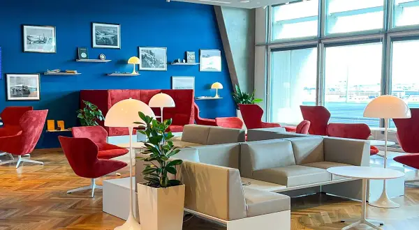 Gemütliche Lounge mit roten Sesseln und grauen Sofas, ideal für Reisende mit Priority Pass Stuttgart.