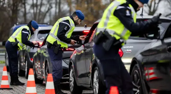 Polizisten kontrollieren Fahrzeuge an der Grenze zur Einreise in die Niederlande.
