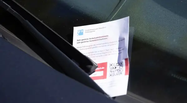 Strafzettel unter Scheibenwischer: Verboten! Ein Zettel vom Ordnungsamt Düsseldorf liegt unter dem Scheibenwischer, der ein Verwarnungsgeld ankündigt.