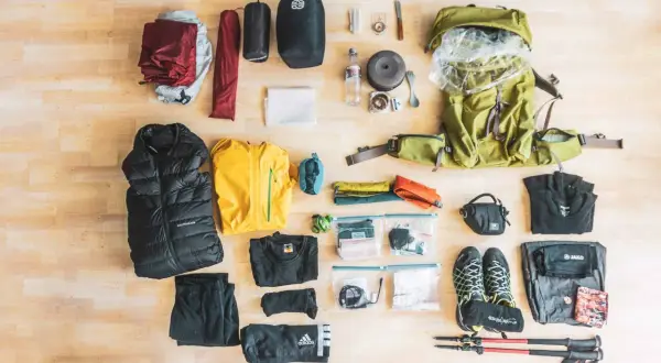 Packliste Wandern 3 Tage: Rucksack, Zelt, Schlafsack, warme Kleidung, Kochutensilien, Schuhe und Wanderstöcke sind bereit für das Abenteuer.