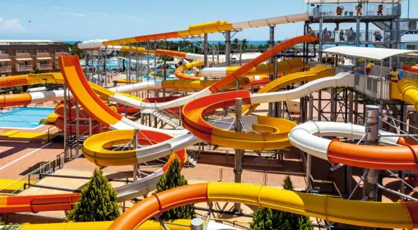 Bunte Wasserrutschen im aqi pegasos world Wasserpark, die sich durch die Luft schlängeln.