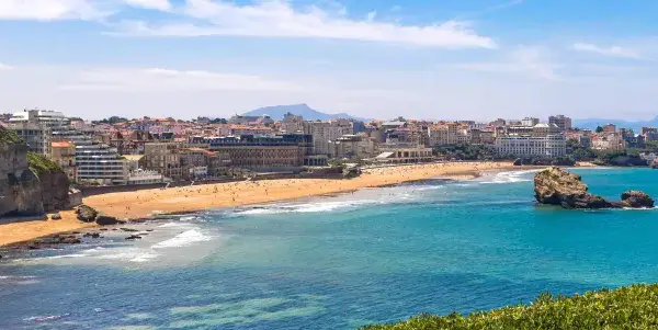 Traumhafter Frankreich Urlaub am Meer: Küstenstadt mit Sandstrand, Felsen und türkisfarbenem Wasser.