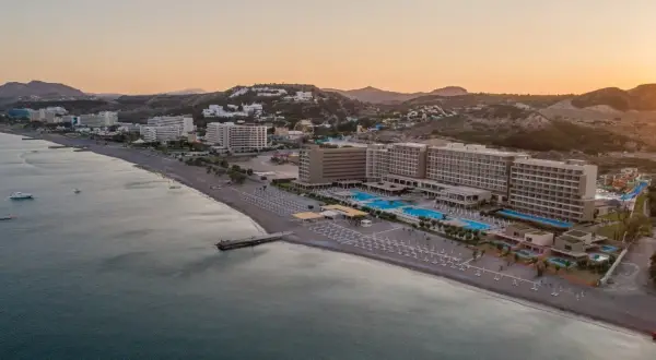 Amada Colossos Resort Rhodos: Weitläufige Hotelanlage mit Pools und Strand am Meer, umgeben von Hügeln.