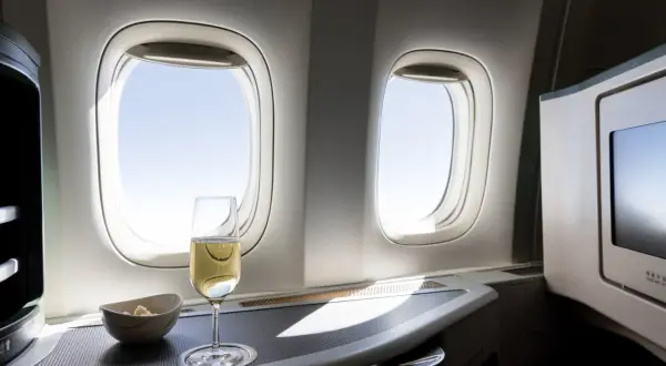 Sektglas und Snack am Fenster im Flugzeug. Ein kostenloses Upgrade Flug, das den Luxus genießt.
