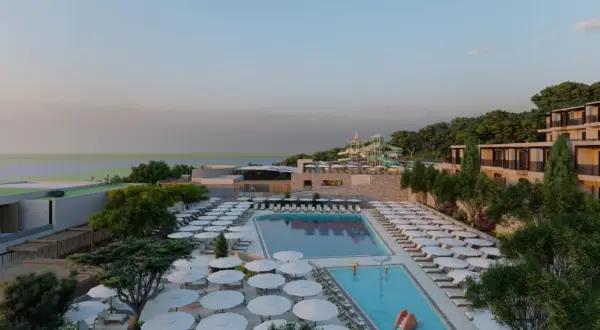 Ein luxuriöses Resort am Elios Hill Kreta mit Pools, Wasserrutschen und Blick aufs Meer. Sonnenschirme und Liegen laden zum Entspannen ein.