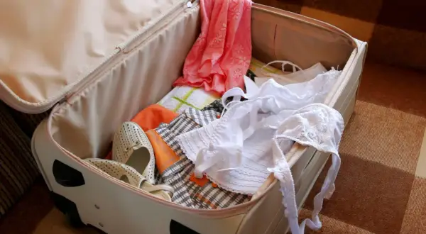Koffer packen tipps knitterfrei: Kleidung, Schuhe und Wäsche liegen bereit.