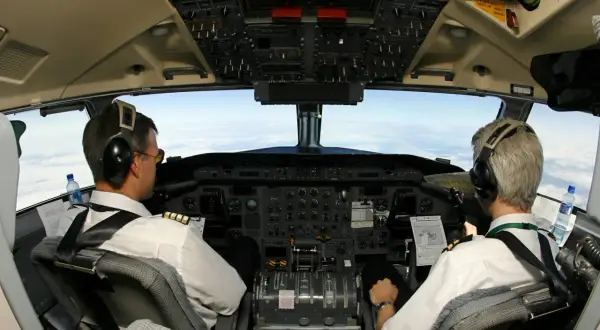 Zwei Piloten im Cockpit, bereit für den Flug. Sie sind das ABC der Piloten, mit Blick auf die Wolken.