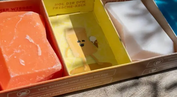 Erste Eindrücke von Duschbrocken: Ein orangefarbener, ein gelber mit Comic und ein weißer festes Shampoo. Umweltfreundlich & pflegend.
