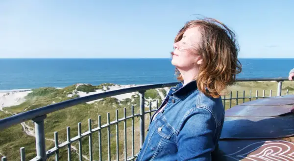 Frauenkopf im Wind, Blick auf die Dünen und das Meer bei Hvide Sande.