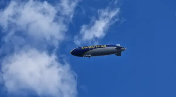 Ein Goodyear-Zeppelin schwebt am blauen Himmel. Wie viele Zeppeline es gibt, ist unklar, aber dieser hier ist gut sichtbar.