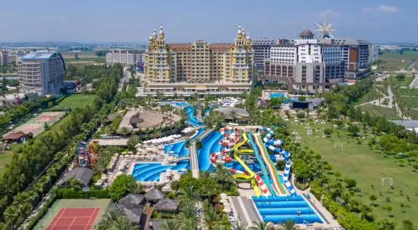 Ein luxuriöser royal holiday palace mit Wasserrutschen, Pools, Tennisplätzen und viel Grün.