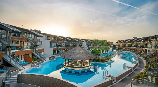 Ein luxuriöser Poolbereich mit Swim-up-Bar im Liberty Fabay, umgeben von modernen Hotelgebäuden und Palmen.