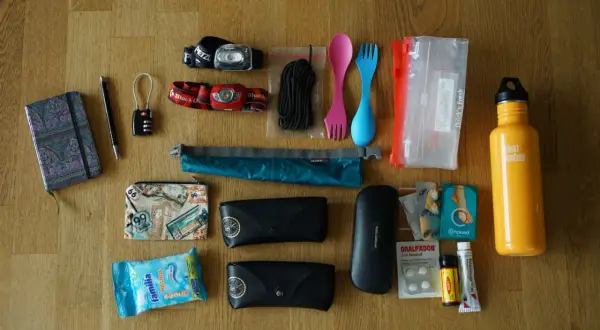 Packliste Jordanien: Notizbuch, Stift, Schloss, Stirnlampen, Seil, Besteck, Beutel, Brillenetuis, Sonnenbrille, Reiseapotheke, Wasserflasche.