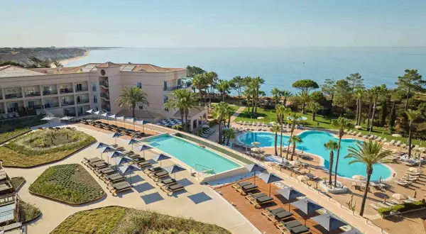 TUI Blue Falesia: Luxuriöses Resort mit mehreren Pools, Liegestühlen und Blick auf das Meer.