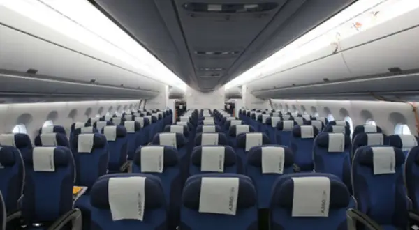 Reihe von blauen Flugzeugsitzen mit weißen Kopfstützen. Ein Sitzplatz D ist in der Mitte des Bildes zu sehen.