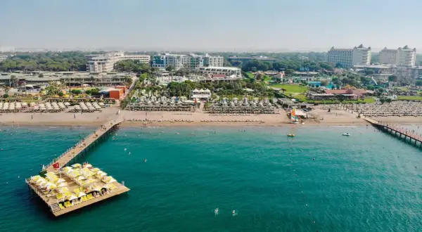 Traumhafter Blick auf das Limak Atlantis De Luxe Hotel & Resort mit Strand, Steg und türkisfarbenem Meer.