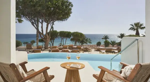 Entspannter Blick vom daia slow beach hotel conil auf den Pool und das Meer. Zwei Gläser Wein und ein Buch warten auf Sie.