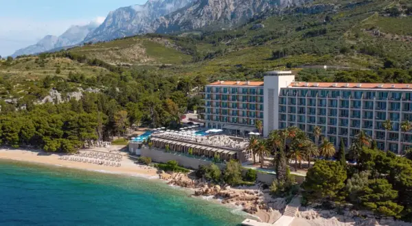 TUI Blue Jadran: Ein Hotel am Strand mit Pool und Bergen im Hintergrund, an der türkisfarbenen Adria.