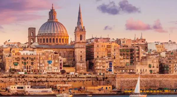 Sonnenuntergang über Valletta, Malta. Die Kuppel der St. Paul's Cathedral und die St. John's Co-Cathedral dominieren die Skyline. Ein perfekter Ort für einen Urlaub.