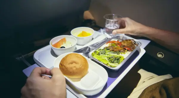 Flugzeugessen: Ab wann gibt es Essen? Ein Tablett mit Lachs, Brötchen, Dessert und Hauptgericht.
