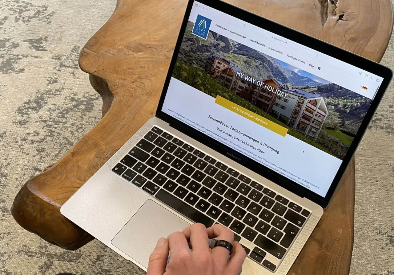 Laptop zeigt Webseite für Ferienhäuser in den Alpen. Perfekt für die einkaufsliste urlaub selbstversorger.
