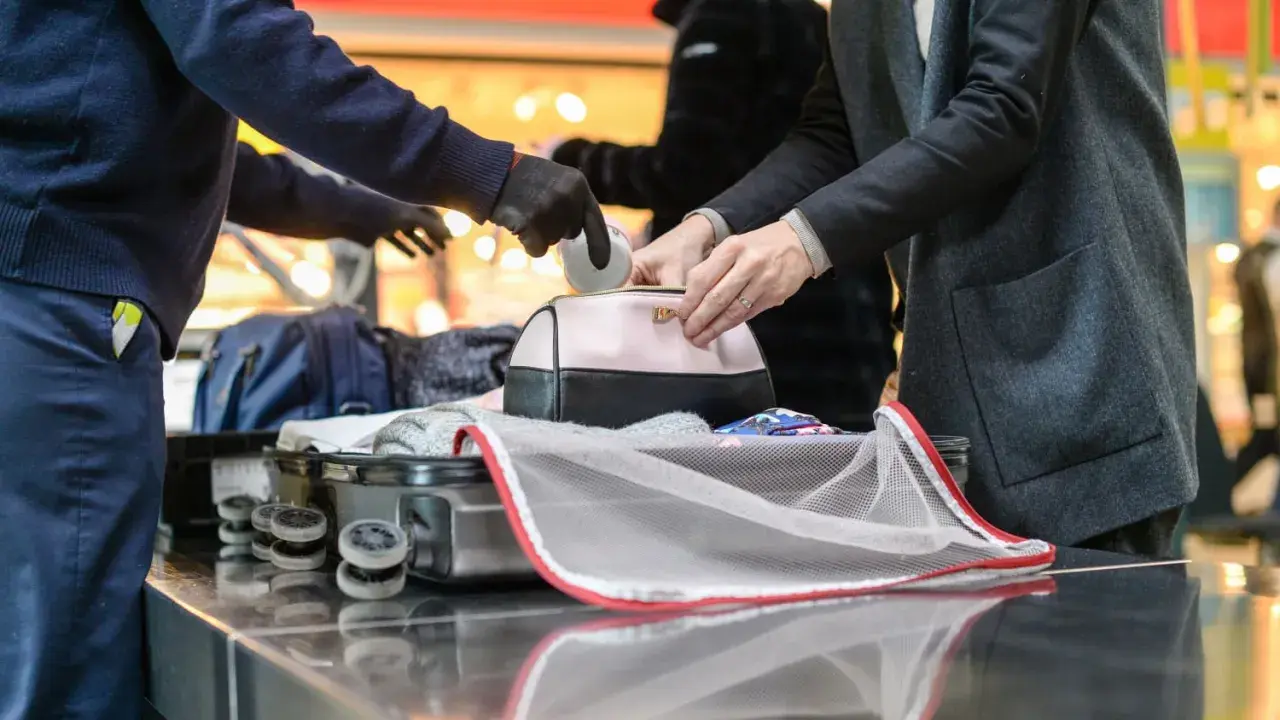 Sicherheitskontrolle am Flughafen: Medikamente werden aus einer Kosmetiktasche genommen, bevor das Gepäck in den Flugzeug-Container kommt.