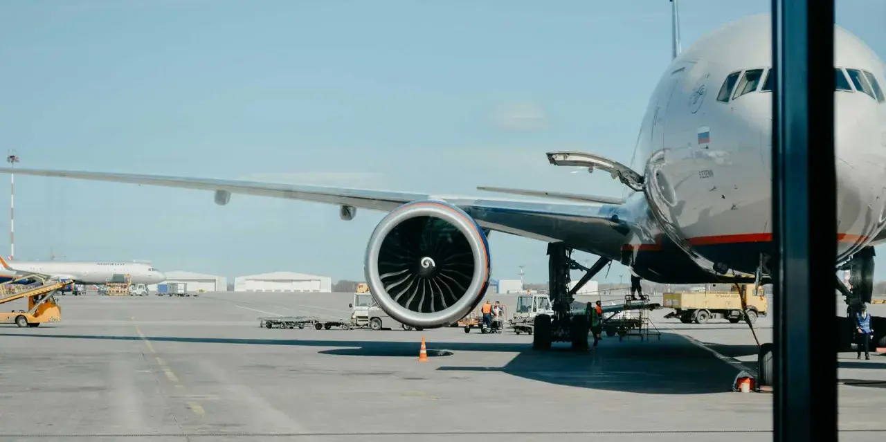 Großes Flugzeug mit geöffneter Ladeluke und Triebwerk auf dem Rollfeld. Bald geht es los, um mit dem Flugzeug fliegen zu können.