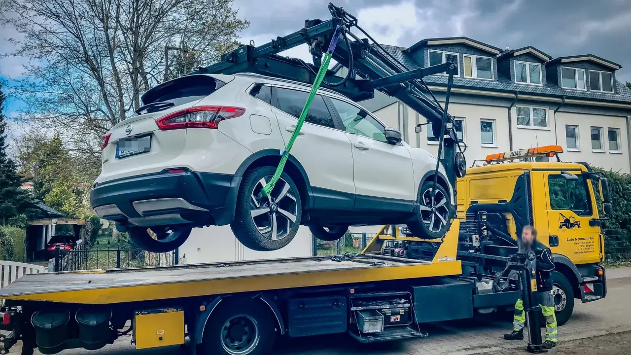 Ein weißer Nissan wird von einem Abschleppwagen in Frankfurt auf die Ladefläche gehoben. Die Abschleppkosten sind hier wohl im Service enthalten.