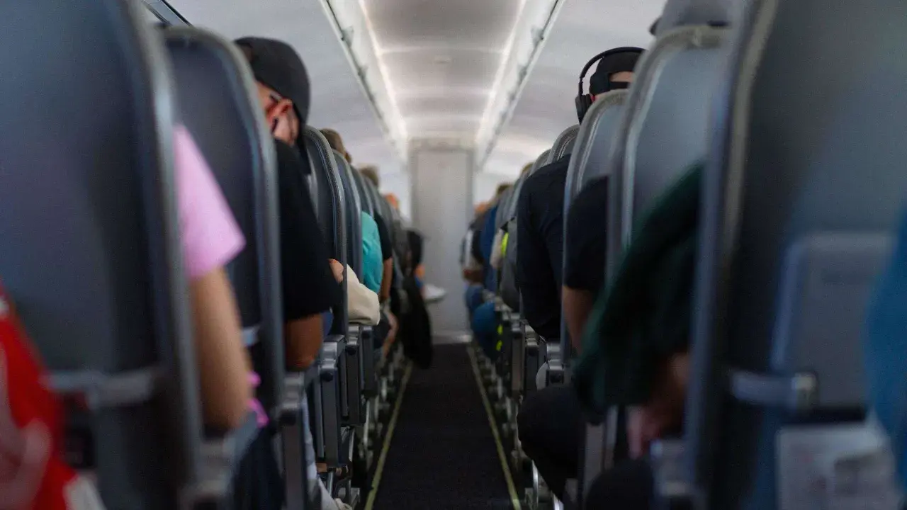 Blick in die Kabine eines Flugzeugs mit Passagieren auf ihren Sitzen. Die Wahrscheinlichkeit eines Flugzeugabsturzes ist extrem gering, aber die Enge hier lässt einen über alles nachdenken.