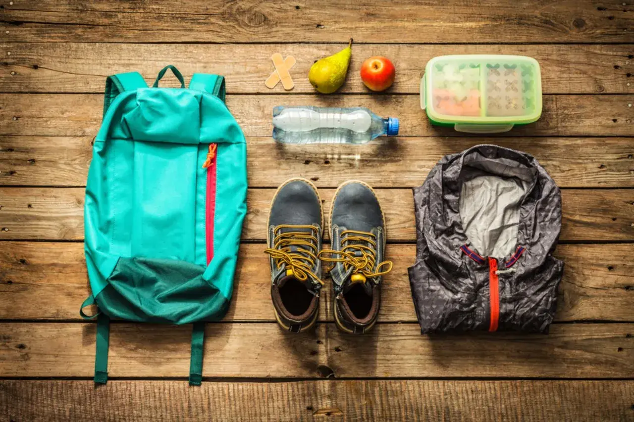 Rucksack, Schuhe, Jacke, Wasserflasche, Obst, Lunchbox und Pflaster – alles für die Packliste Klassenfahrt Lehrer.