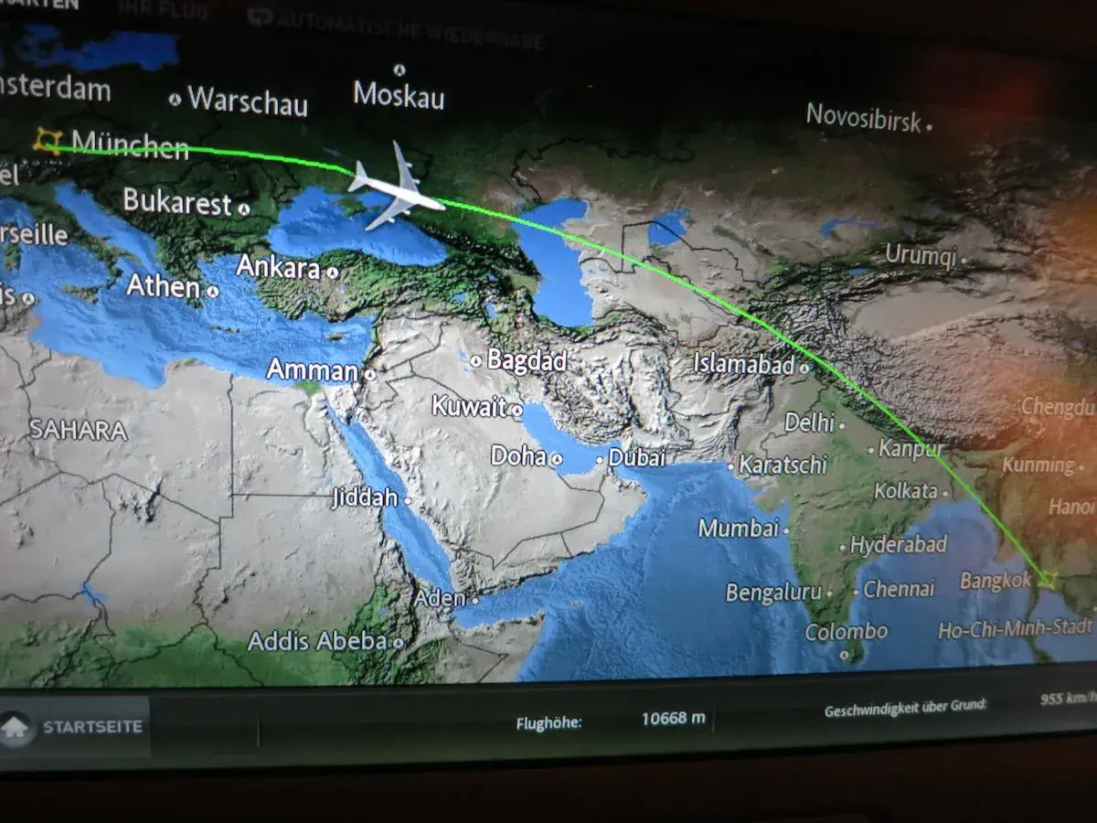 Flugroute von München nach Bangkok. Die Frage "wie lange fliegt man nach Thailand" wird durch die angezeigte Flugbahn über Asien beantwortet.