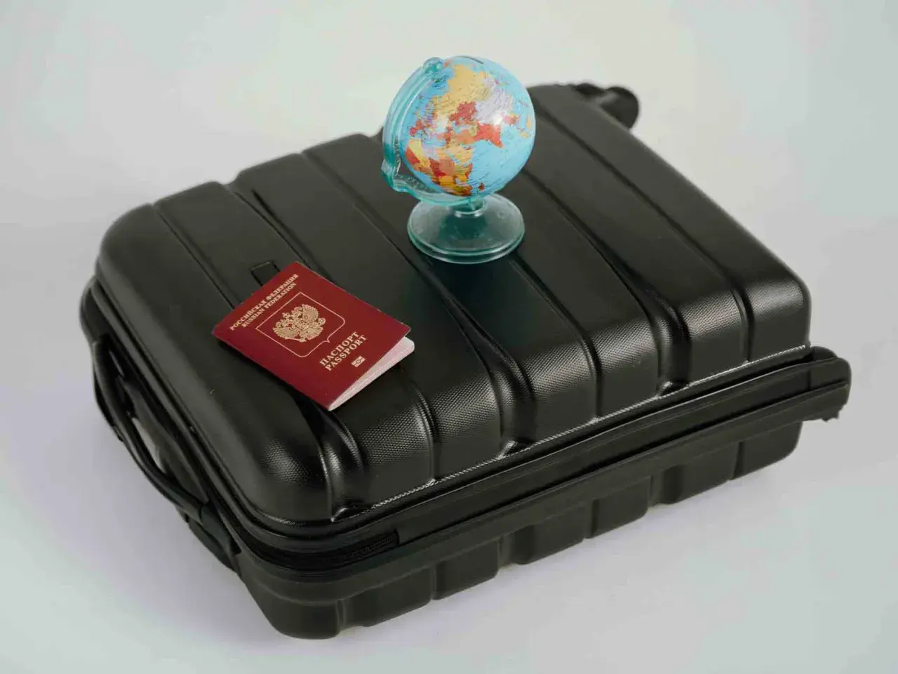 Reisekoffer mit Reisepass und Globus. Wo kann man Geld wechseln? Am Flughafen oder in der Bank.