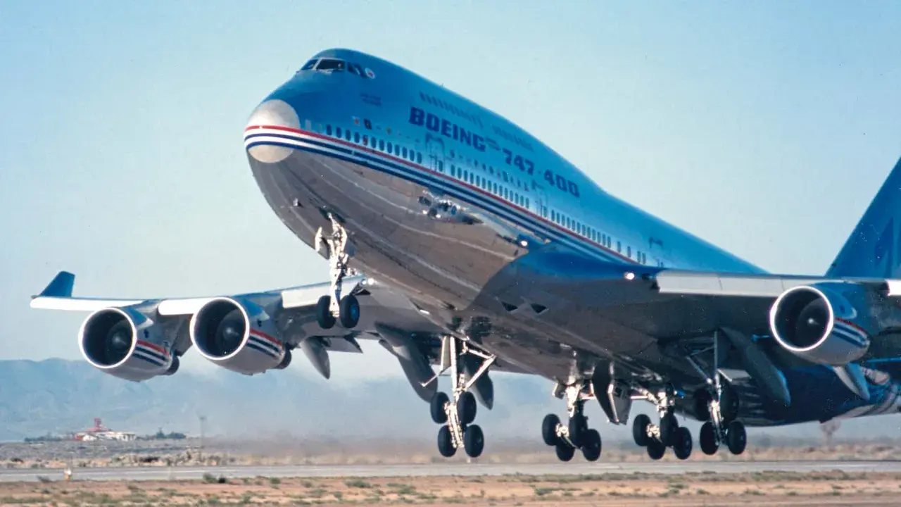 Ein Jumbo Jet 747 hebt ab, seine vier Triebwerke dröhnen.