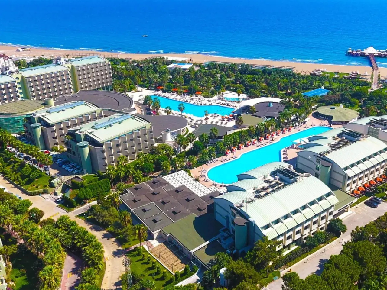 Luftaufnahme des von Resort Golden Coast, mit mehreren Gebäuden, Pools und dem Meer im Hintergrund.