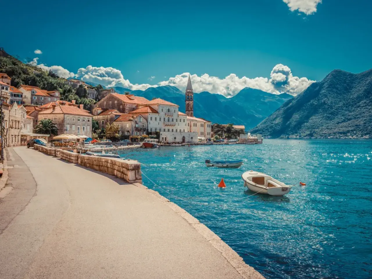 Traumhafte Küstenstadt mit roten Dächern und Booten im türkisfarbenen Wasser. Ein perfektes Beispiel für Urlaubsziele in Europa.