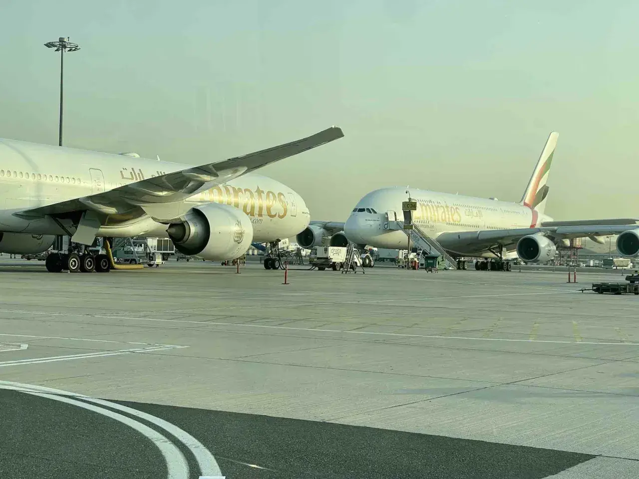 Zwei Emirates-Jets am Flughafen. Ein A380 im Vergleich zu einem kleineren Flugzeug.