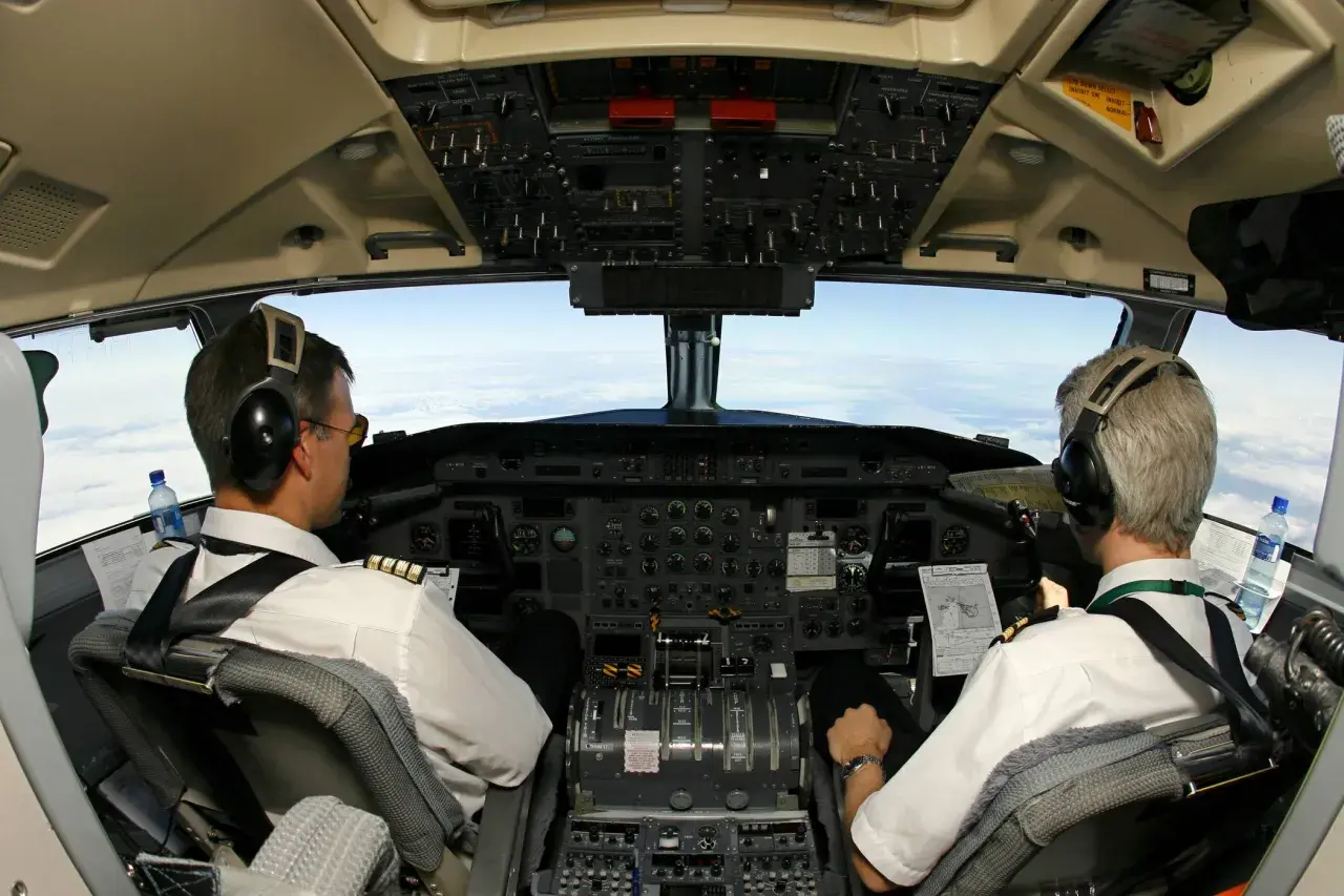 Zwei Piloten im Cockpit, bereit für den Flug. Sie sind das ABC der Piloten, mit Blick auf die Wolken.